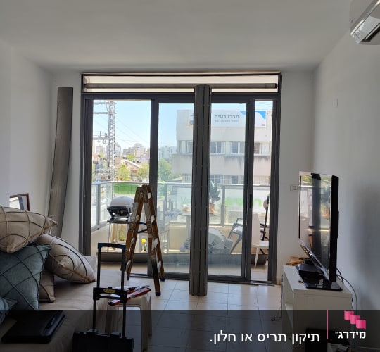תריסים מותקנים על חלון זכוכית בסלון מואר